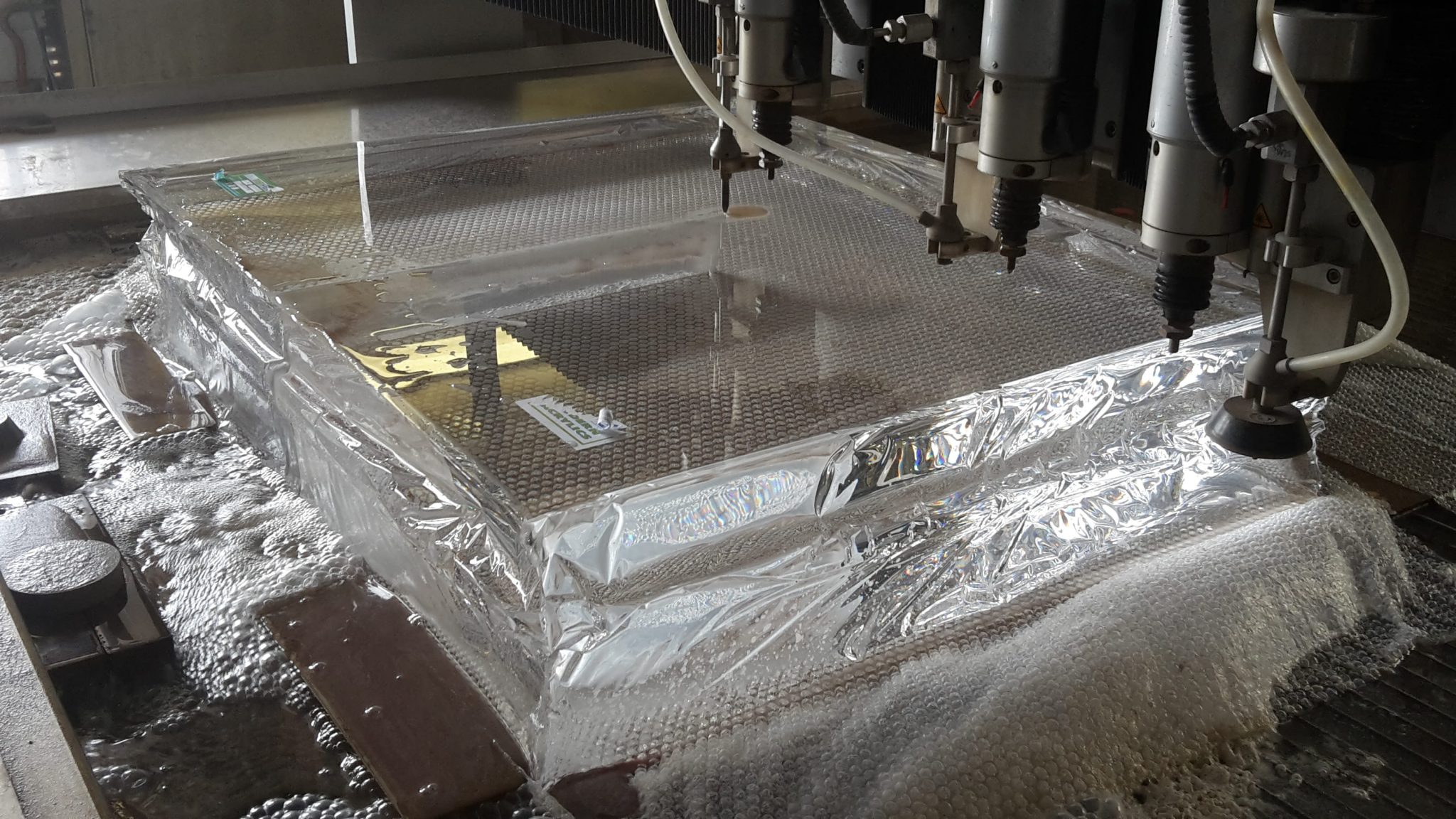 Edelstahlteile und Bleche mit Schutzfolie in Produktionshalle mit Wasserstrahlschneideanlagen bei Klumpp.
