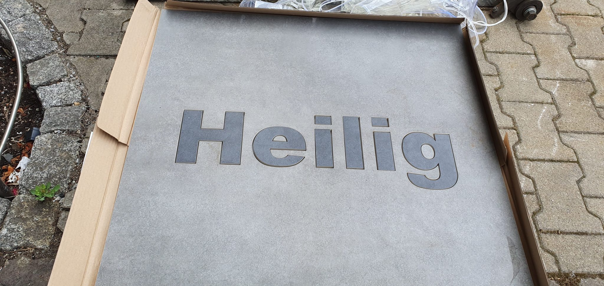 Edelstahlschild mit eingelassenem Text Heilig für Klumpp Edelstahlverarbeitung, Wasserstrahlschneiden in Altlußheim.
