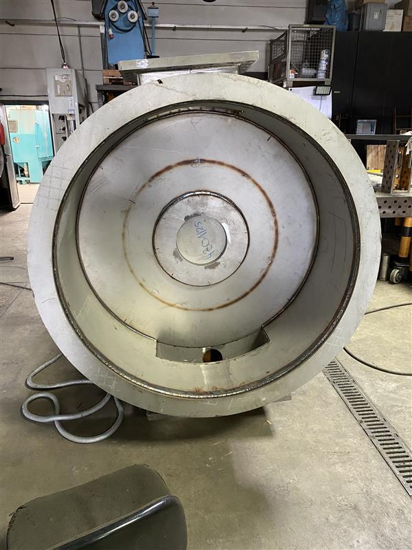 Großer runder Edelstahlbehälter mit konzentrische Kreisen in Werkstatt, Wasserstrahlschneidetechnik sichtbar.