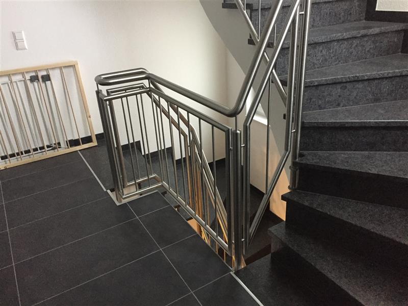 Edelstahl-Treppengitter mit modernem Design an Innentreppe, professionelle Metallverarbeitung und Sicherheitsgeländer.