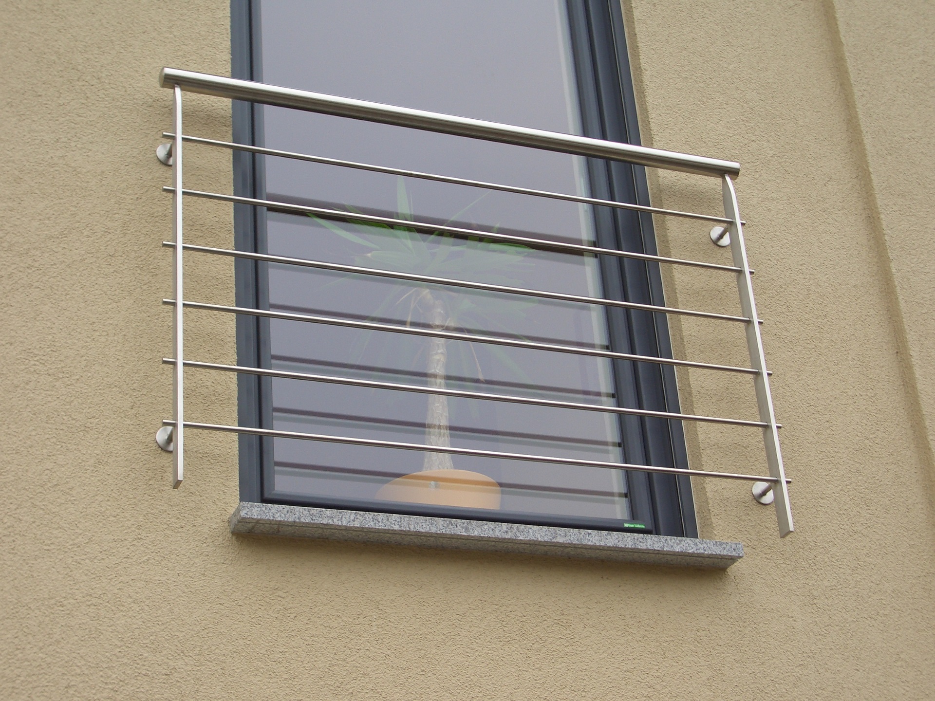 Edelstahl-Fenstergitter mit horizontalen Sprossen an beigefarbenem Gebäude, modernes Sicherheitsgitter.