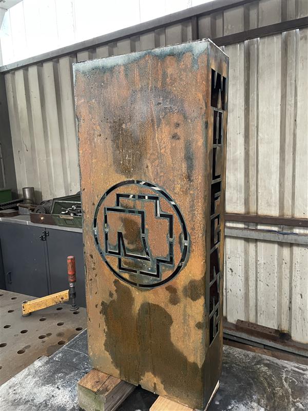 Rostiges Stahlblech mit ausgeschnittenem geometrischem Kreismuster, in Werkstatt mit Wellblechdach, Klumpp Edelstahlverarbeitung.