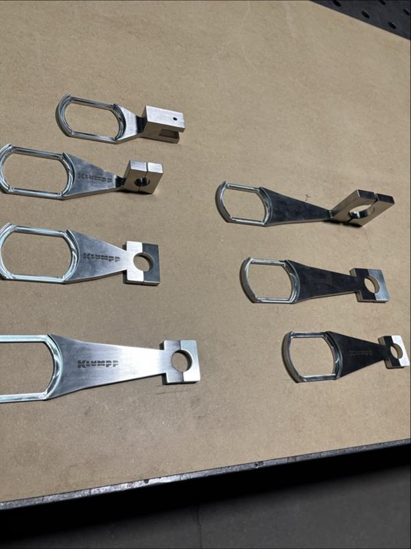 Edelstahlbeschläge und Metallverbindungselemente mit Ösen und Befestigungslöchern auf Pappe arrangiert.