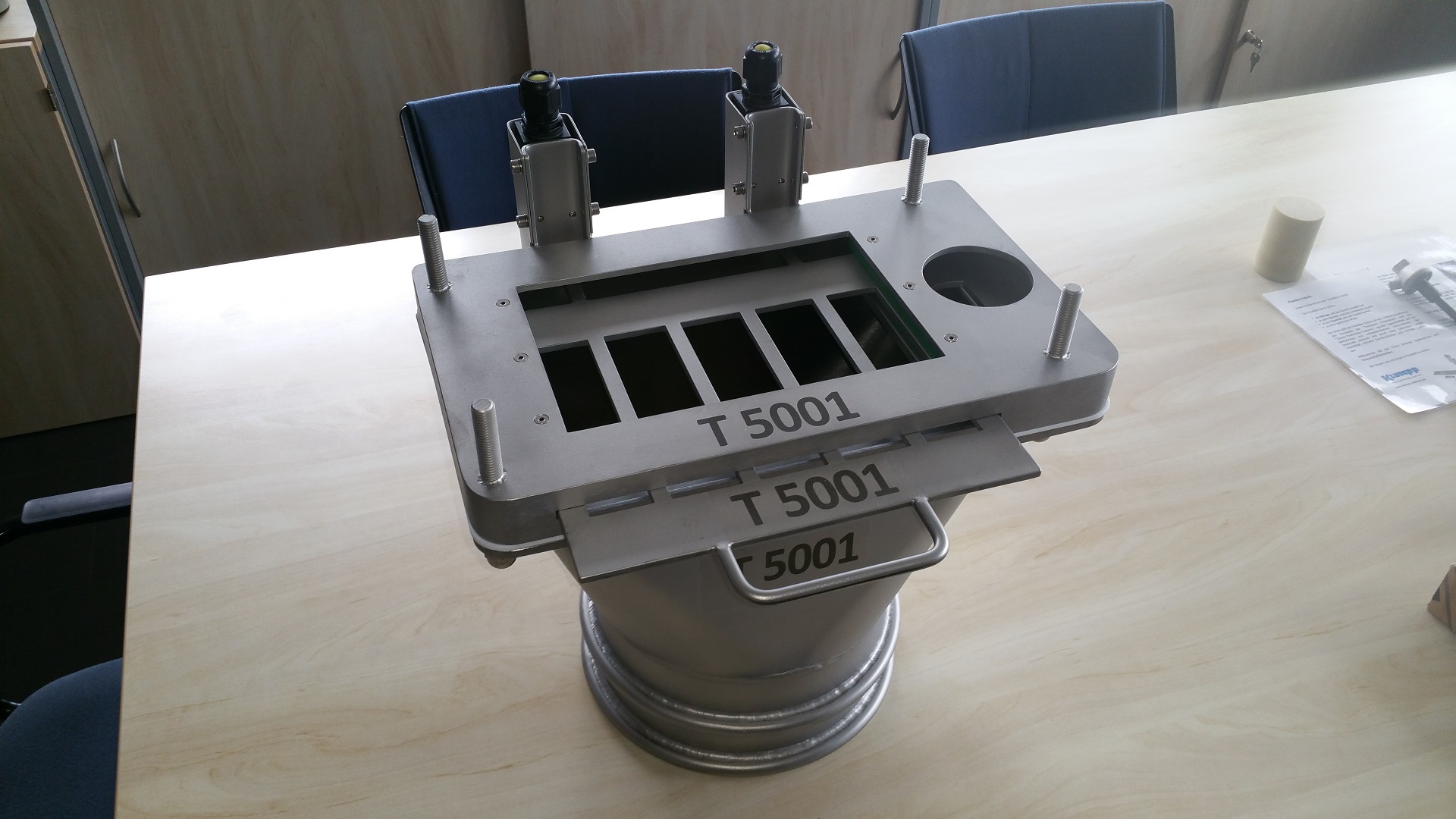 Edelstahl-Demonstrationsmodell T 5001 für Wasserstrahlschneiden auf Konferenztisch, zeigt Schneidplattformen und Präzisionstechnik.