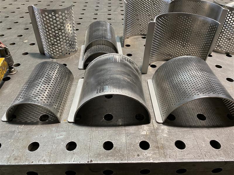 Edelstahl-Siebzylinder und perforierte Metallteile auf Werkbank, Klumpp Edelstahlverarbeitung Altlußheim.